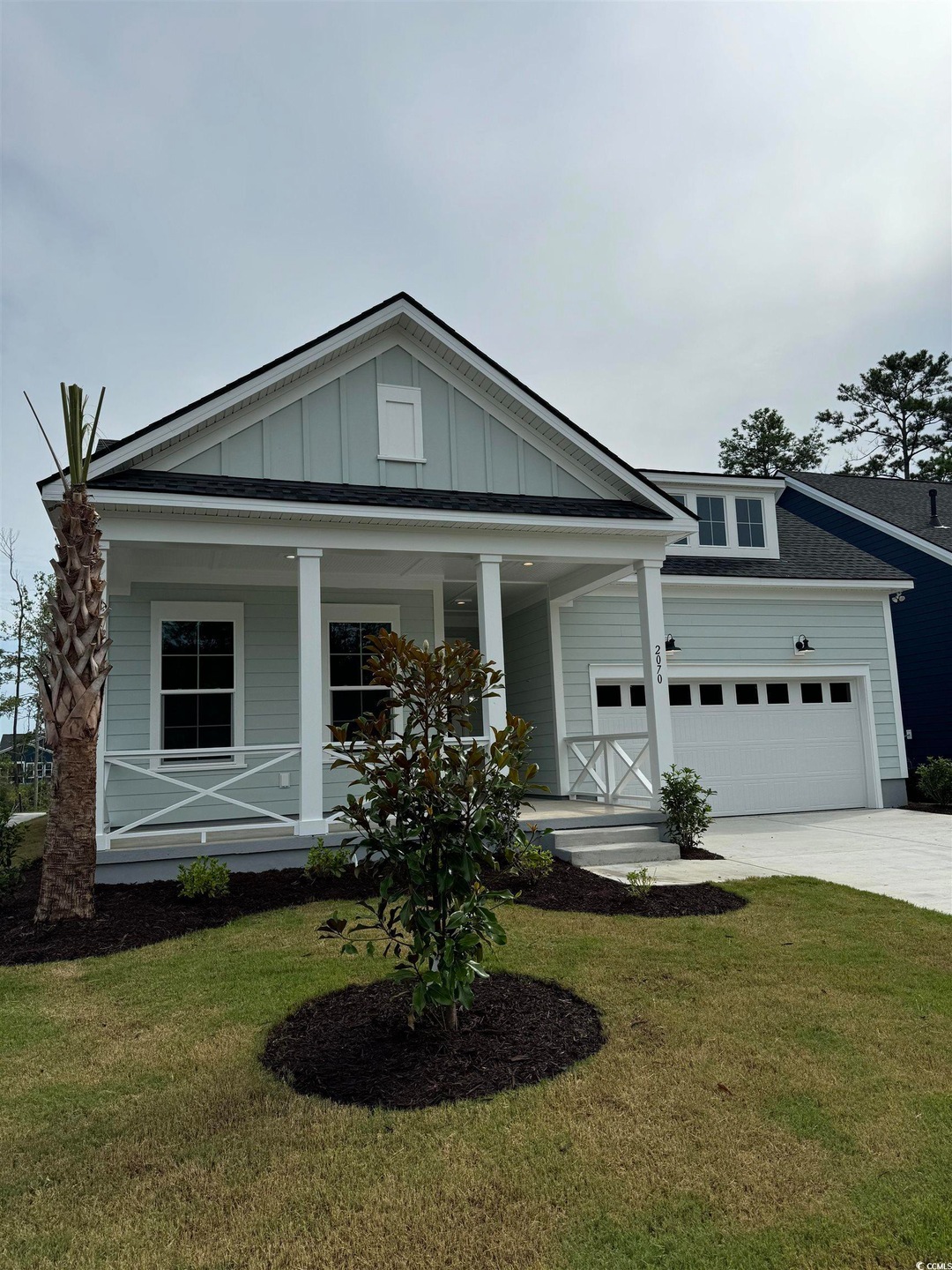 View of front of house with a garage, covered porch, and a front yard