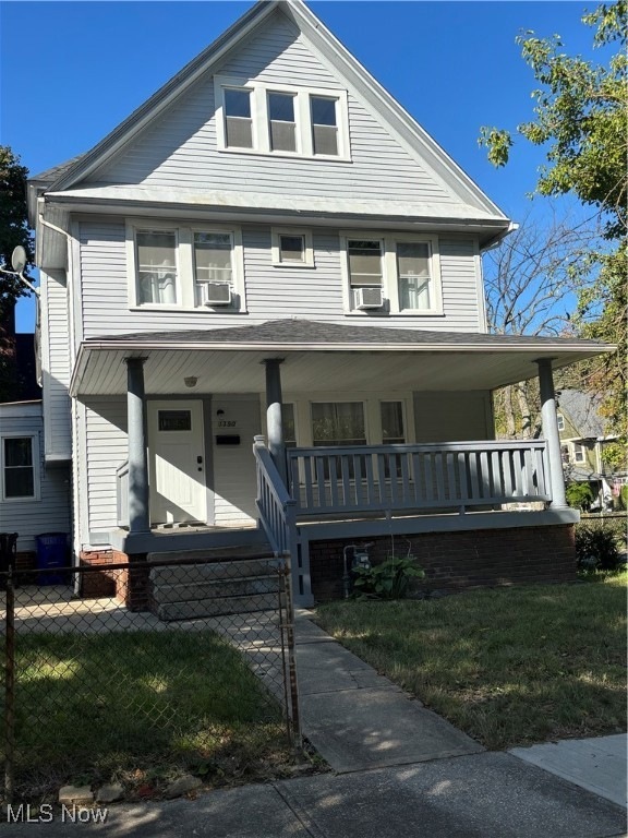 View of front facade with covered porch and a front yard