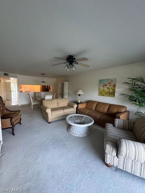 Living room with carpet, a textured ceiling, and c