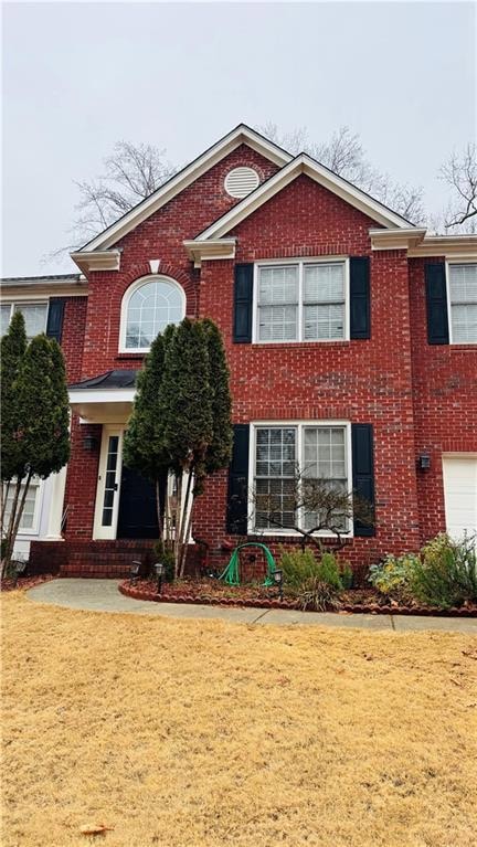 View of front facade with a front yard and brick siding