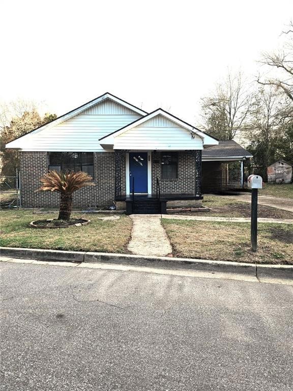 View of front of house with a front lawn and brick