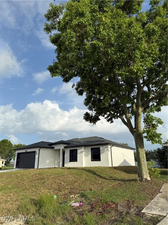 View of front of property featuring a garage, stuc