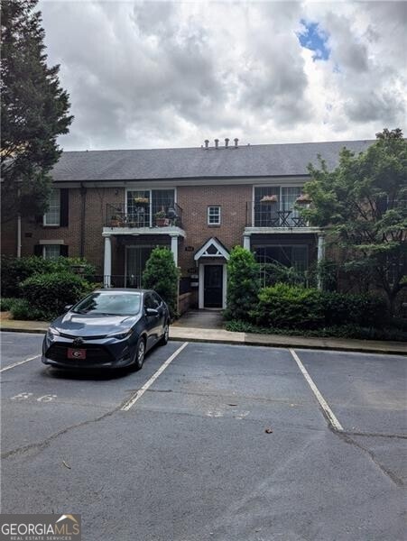 View of front of house with uncovered parking and brick siding