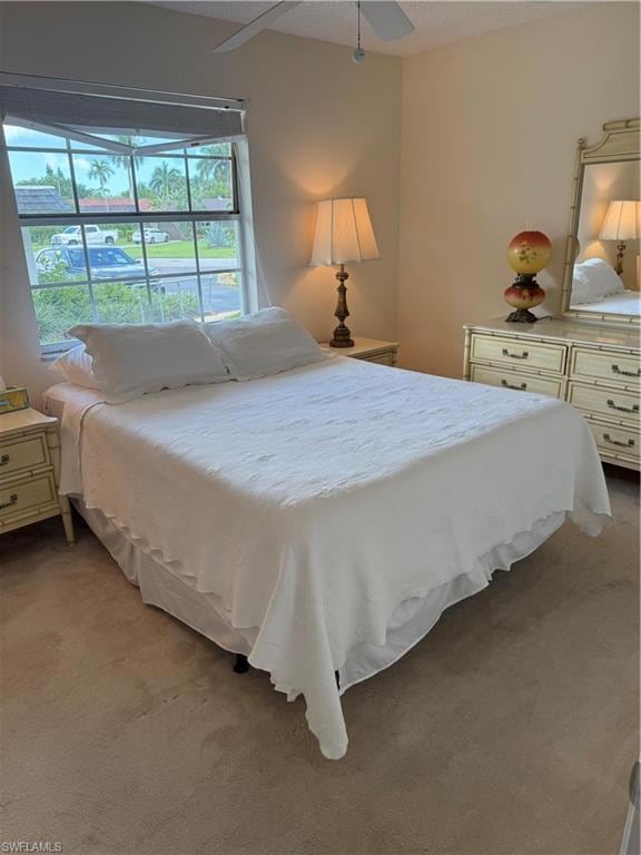 Bedroom featuring light colored carpet, a textured ceiling, and a ceiling fan