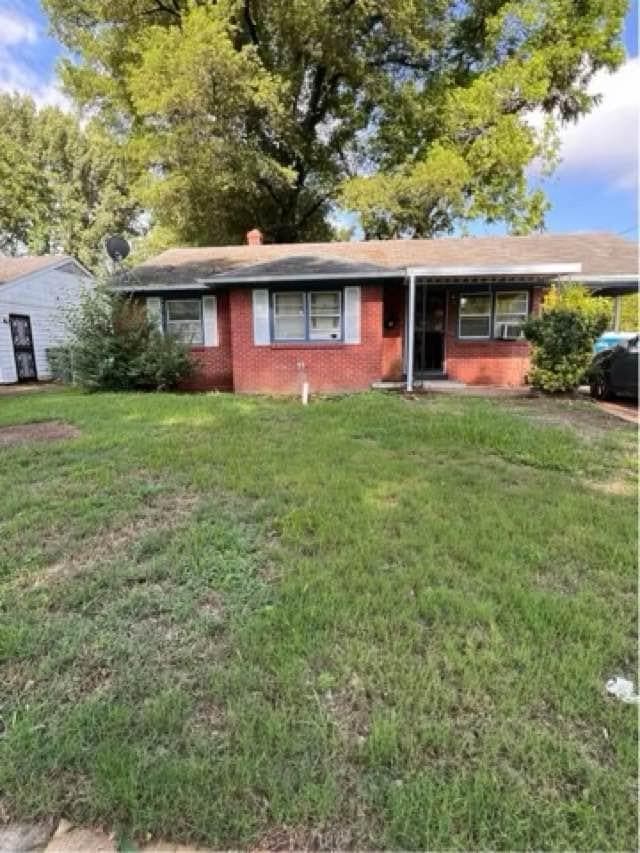 Single story home with brick siding and a front yard