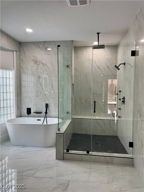 Full bath with a marble finish shower, marble tile