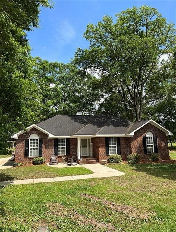 Ranch-style home featuring a front yard and brick siding