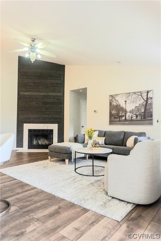 Living room featuring a large fireplace, hardwood