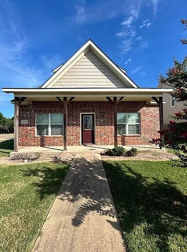 Ranch-style house with a front lawn, covered porch