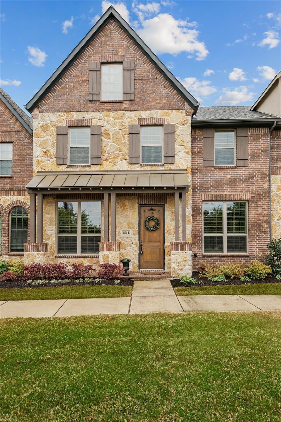 View of front of property with stone siding, brick