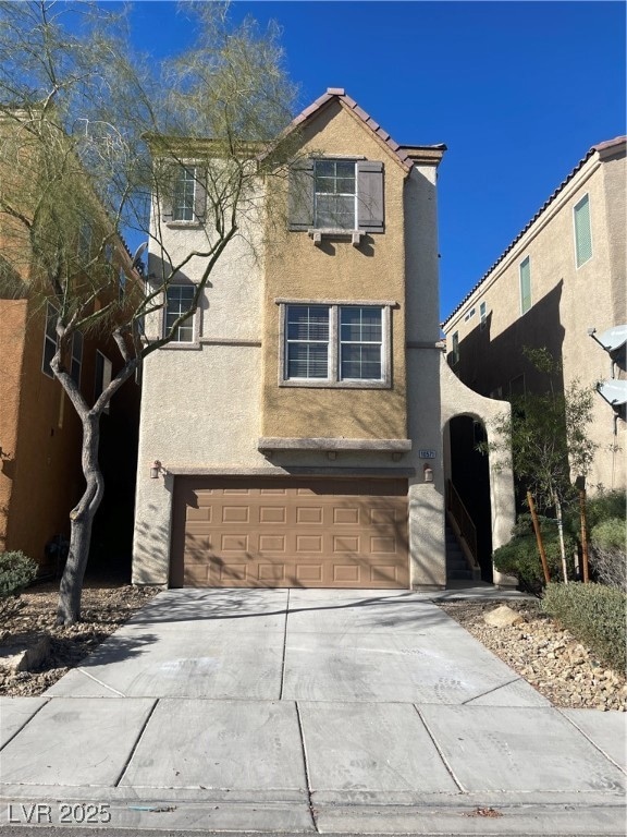 Traditional-style house featuring stucco siding, concrete driveway, and a garage