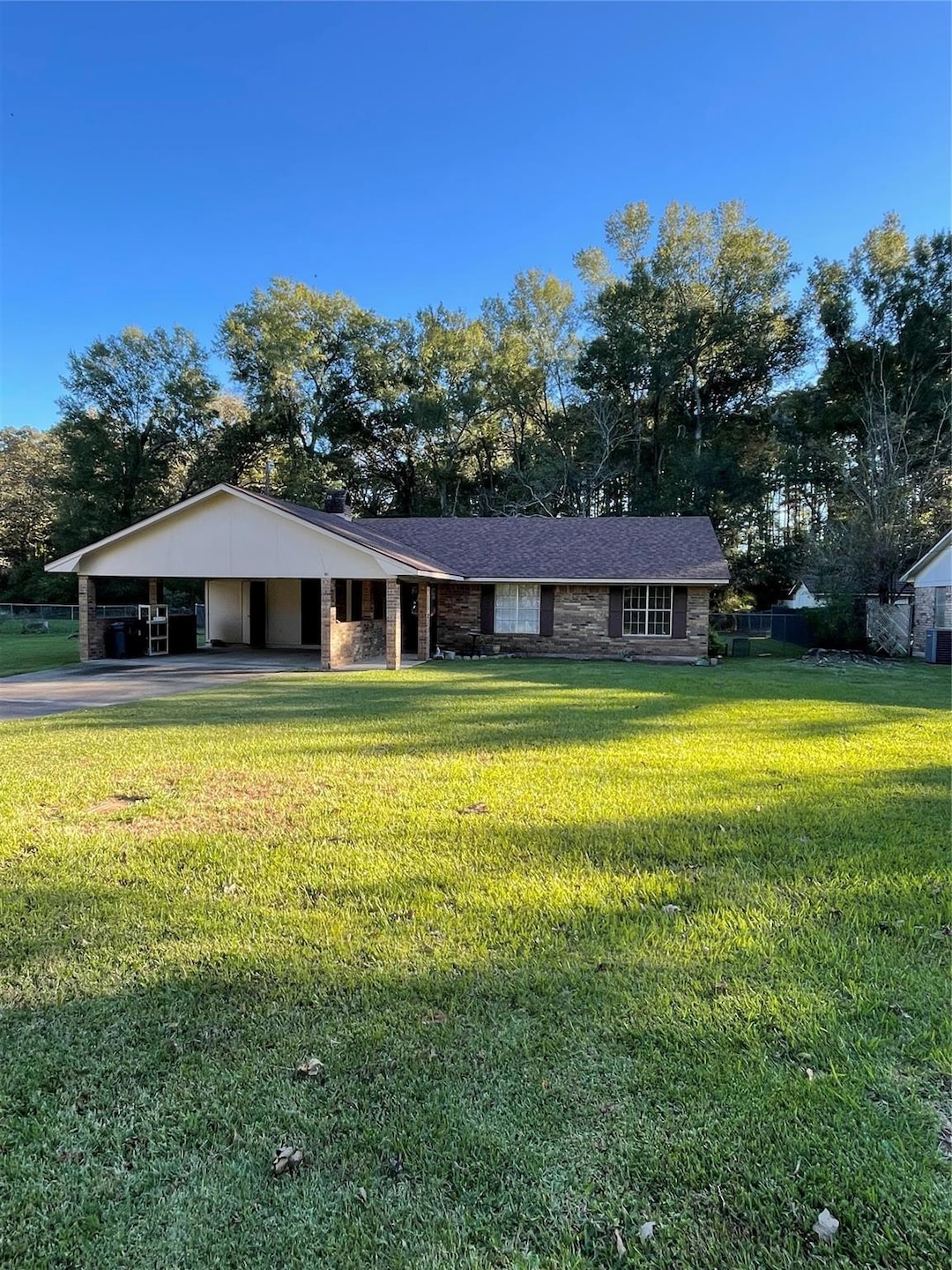 Single story home with a carport and a front lawn