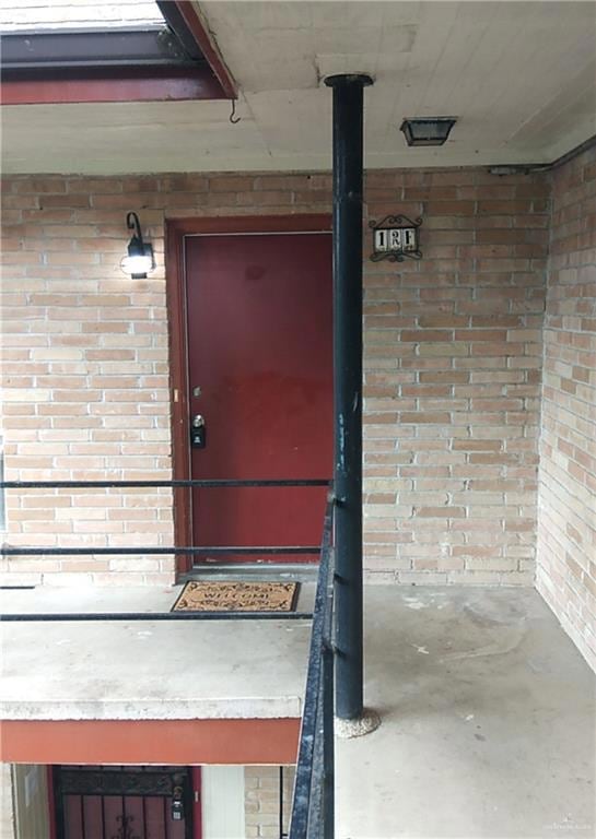 Doorway to property with brick siding