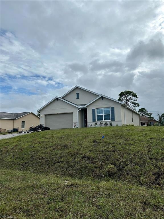 Single story home featuring an attached garage, a front lawn, and stucco siding