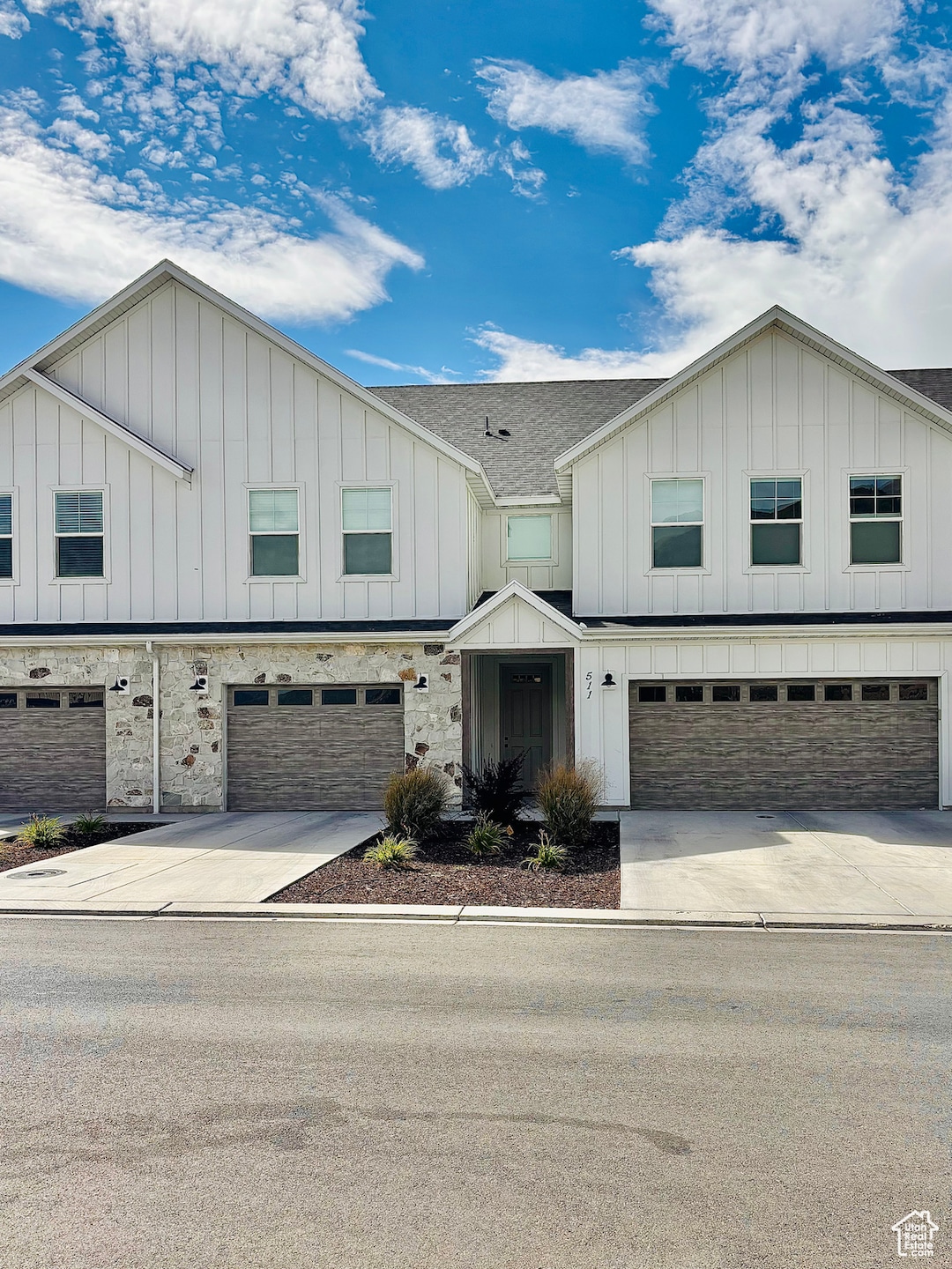 Modern farmhouse featuring board and batten siding, concrete driveway, a garage, and a shingled roof