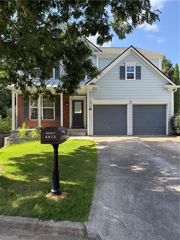 Traditional home with concrete driveway, a front yard, and brick siding