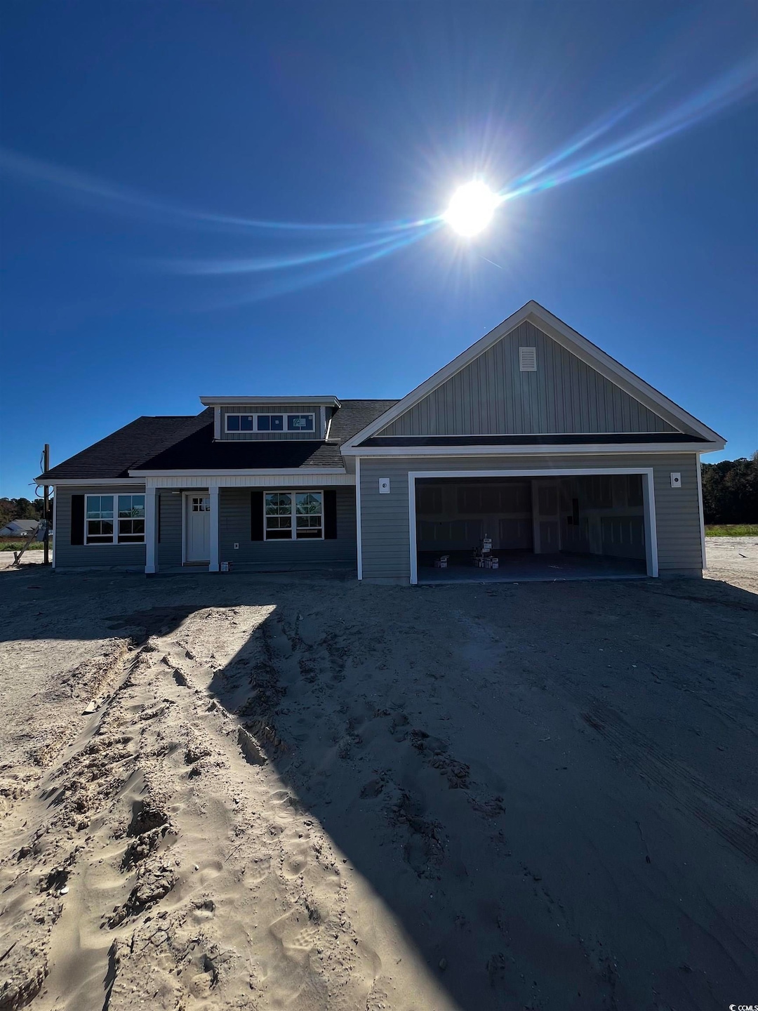 View of front of house featuring driveway, covered porch, and an attached garage