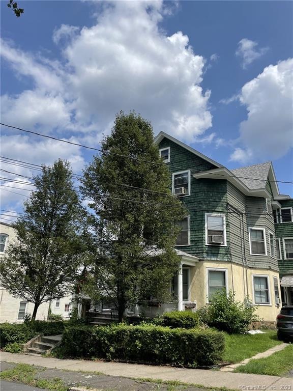 Classic three family on a tree lined street.