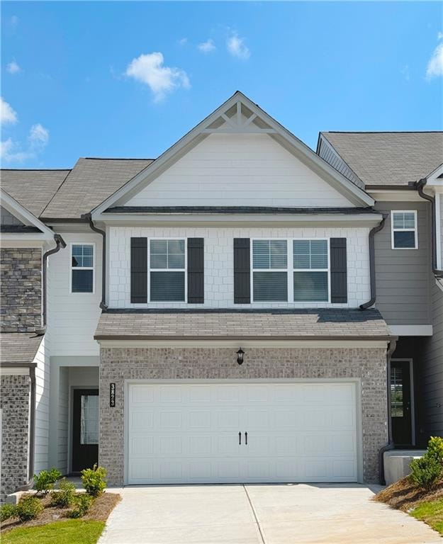 View of front of home with concrete driveway, brick siding, and an attached garage