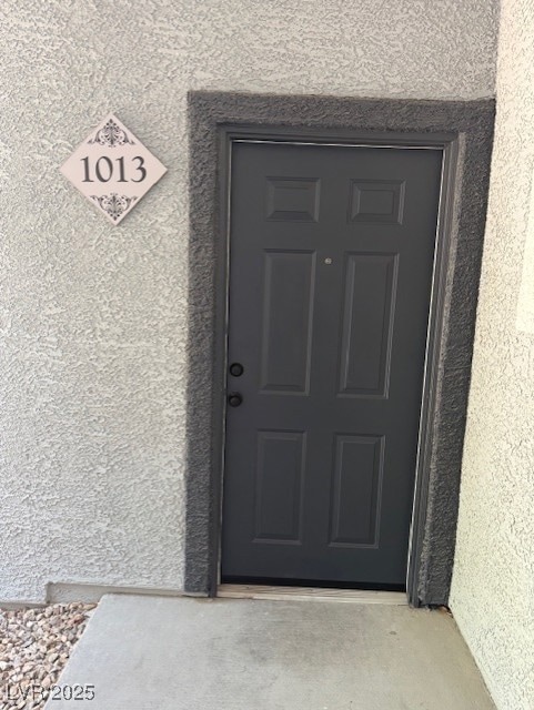 Doorway to property with stucco siding