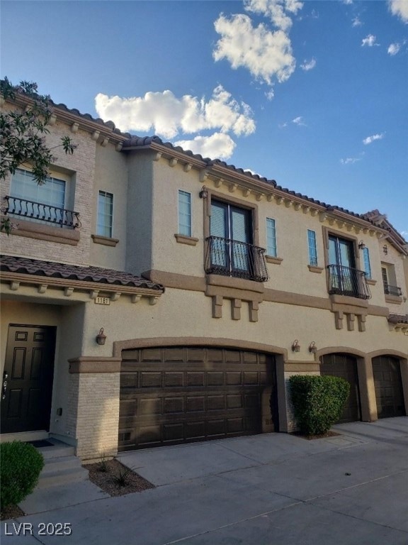 Mediterranean / spanish home with a balcony, an attached garage, stucco siding, and concrete driveway