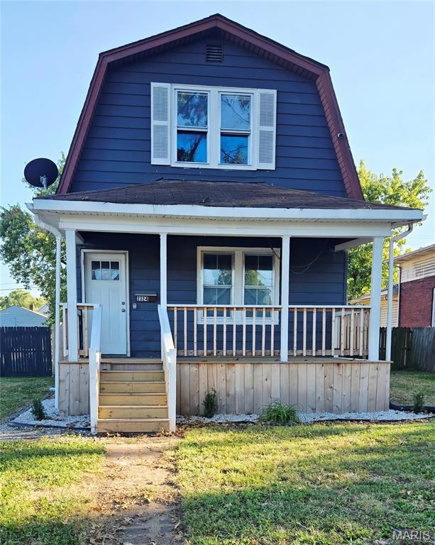 Colonial inspired home featuring a gambrel roof and a porch