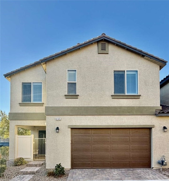 View of front of property with a garage, fence, an