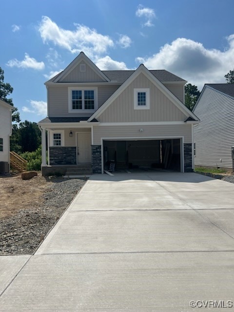 Craftsman house featuring concrete driveway, board