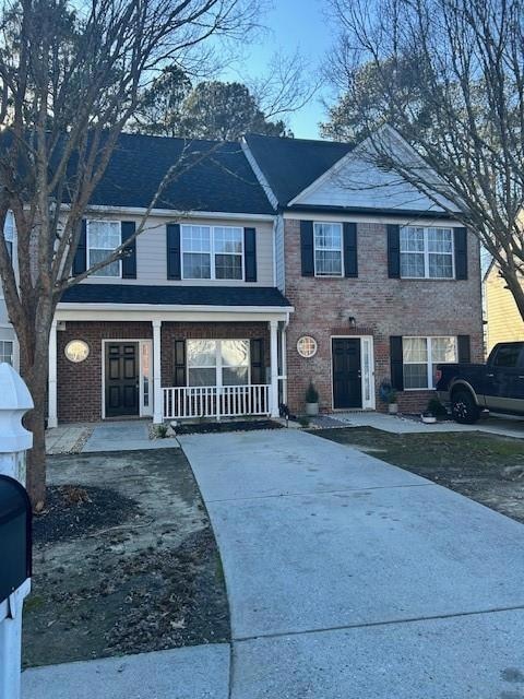 View of front of property with brick siding, cover