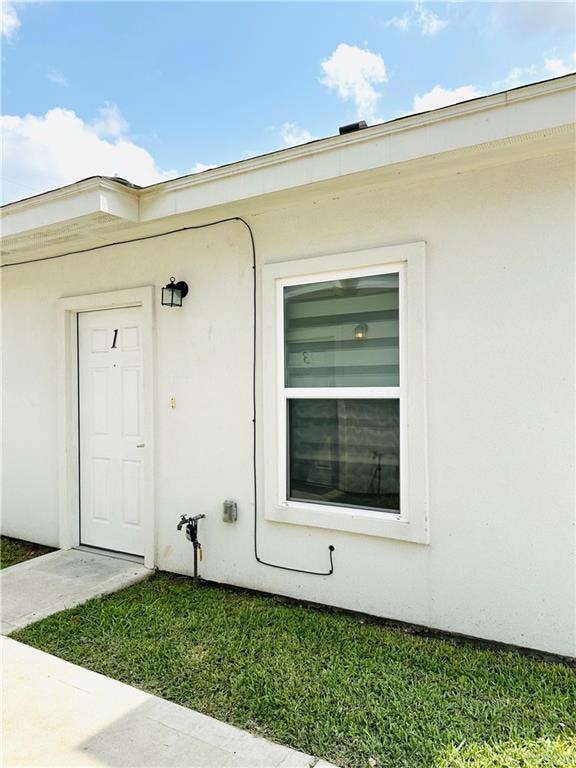 Property entrance featuring stucco siding