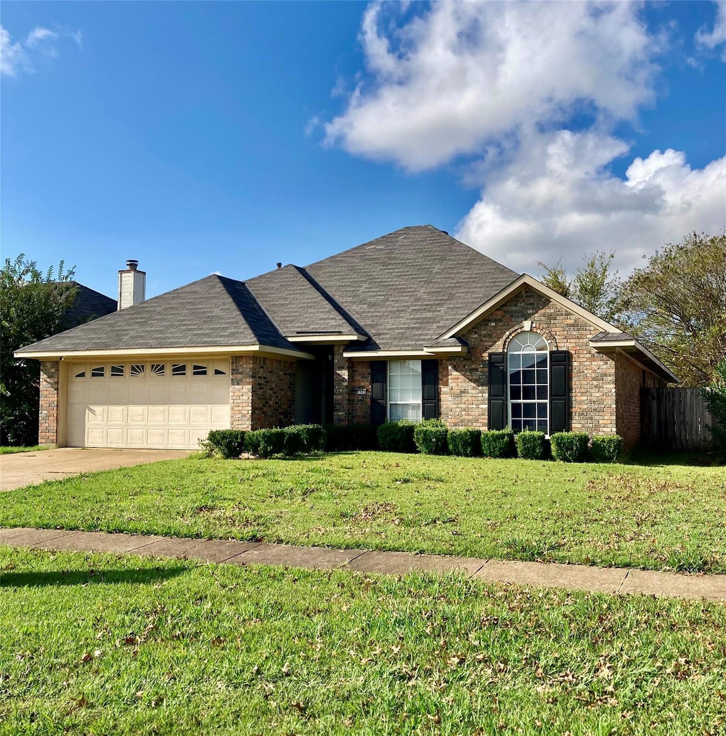 Ranch-style home with a garage and a front yard