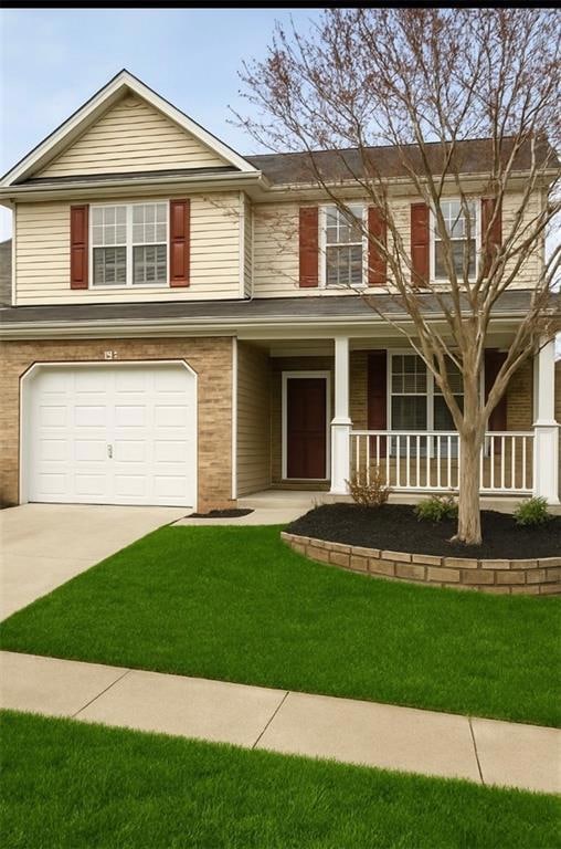 View of front of house featuring covered porch, brick siding, a front lawn, and concrete driveway