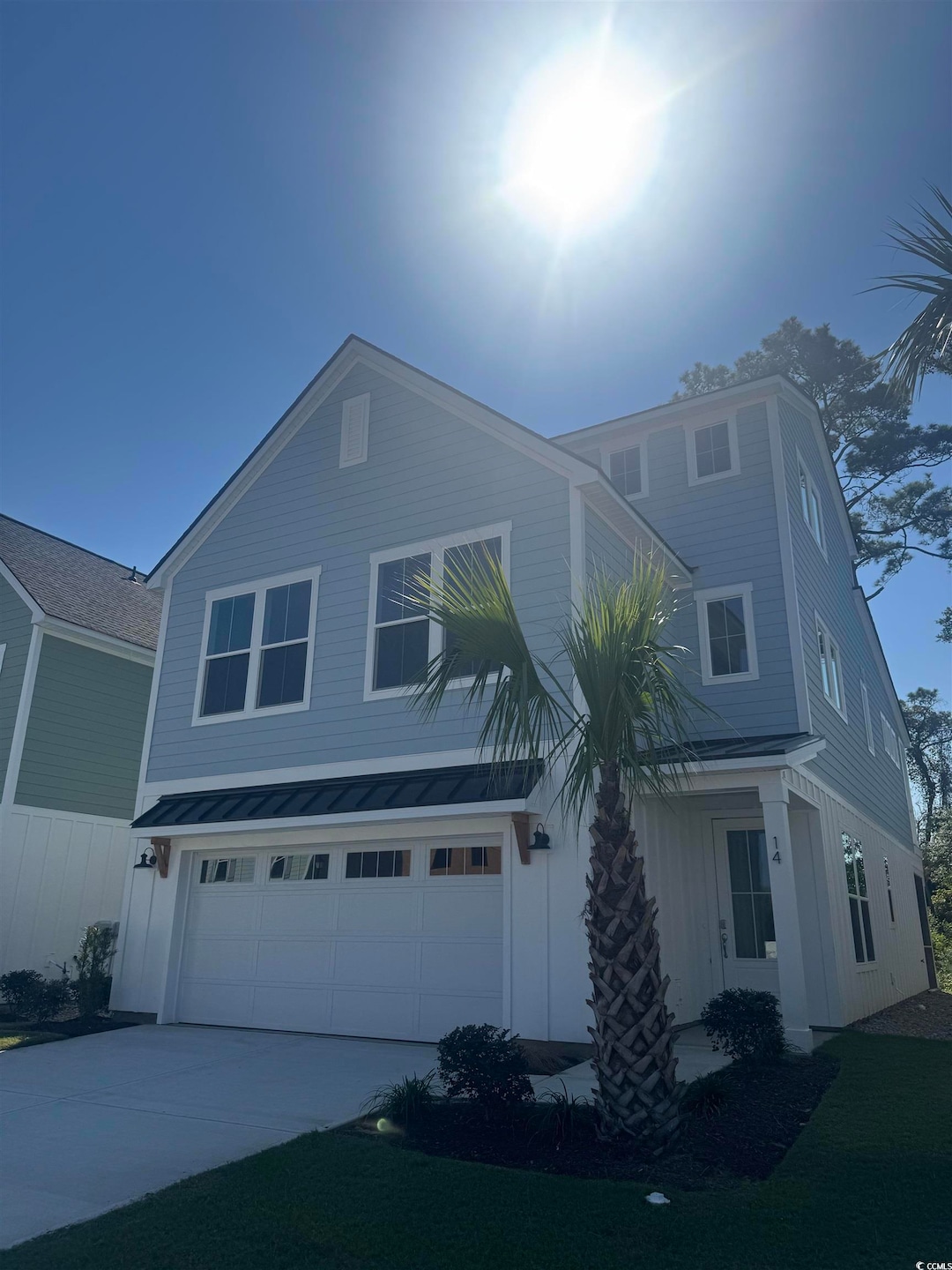 Traditional home featuring an attached garage, driveway, and board and batten siding