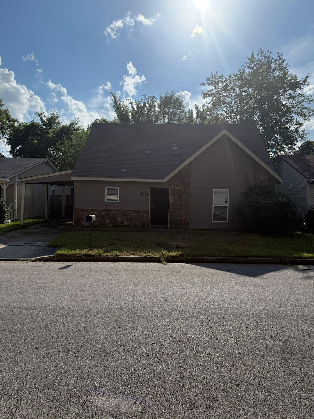 View of front of property featuring a carport, a front lawn, and concrete driveway
