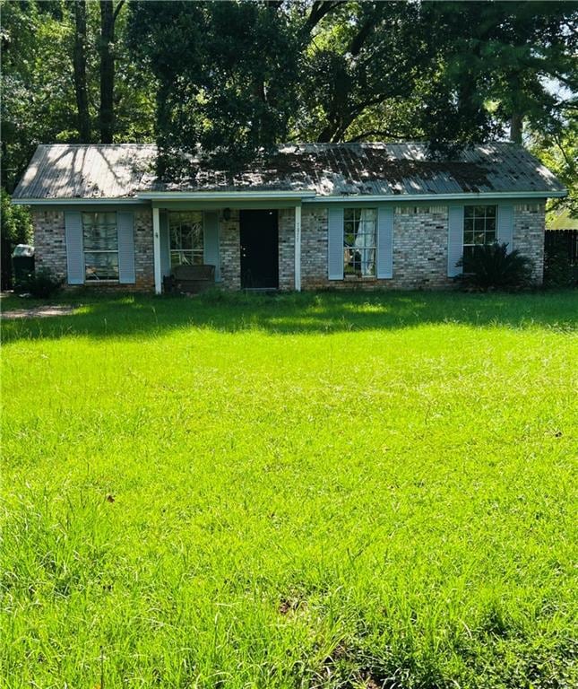 Single story home with a front yard and a metal roof