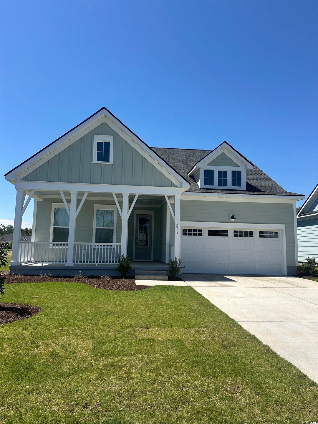Craftsman-style home with a front yard, driveway, 