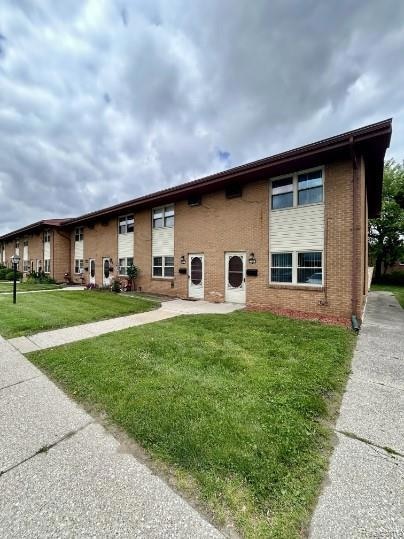 Bi-level home featuring brick siding and a front lawn