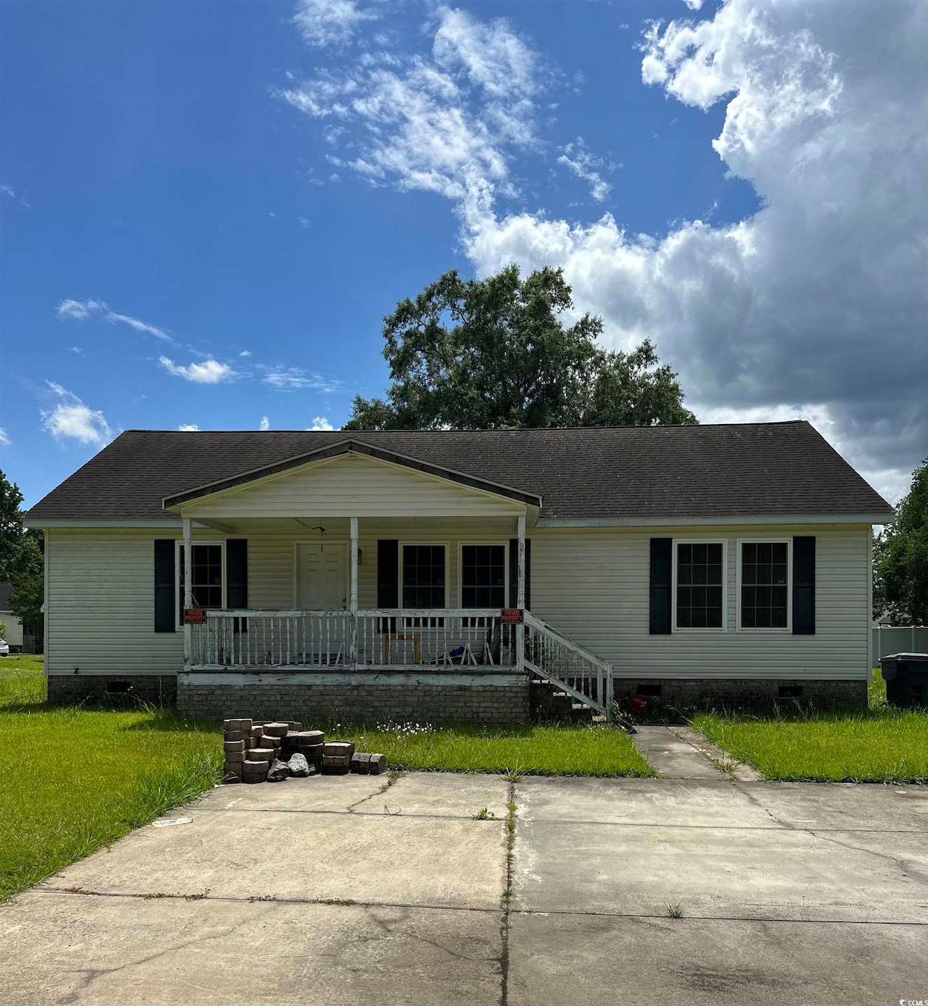 View of front of house with a porch, crawl space, a front lawn, and a shingled roof
