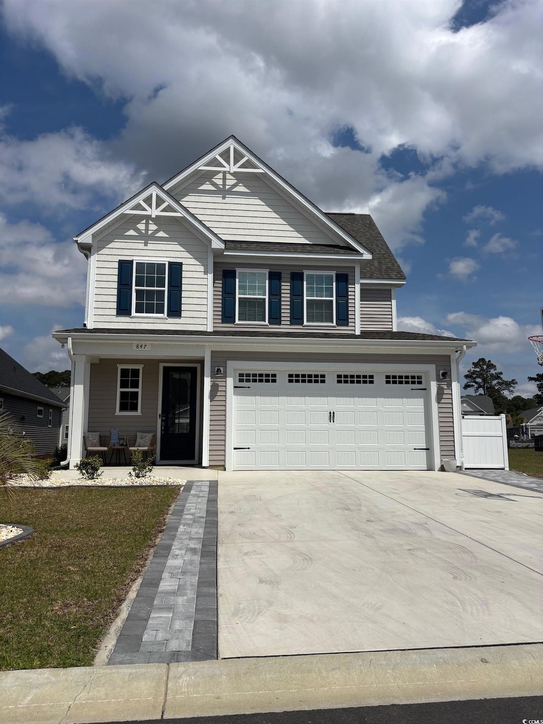 View of front facade featuring driveway, covered porch, and a garage