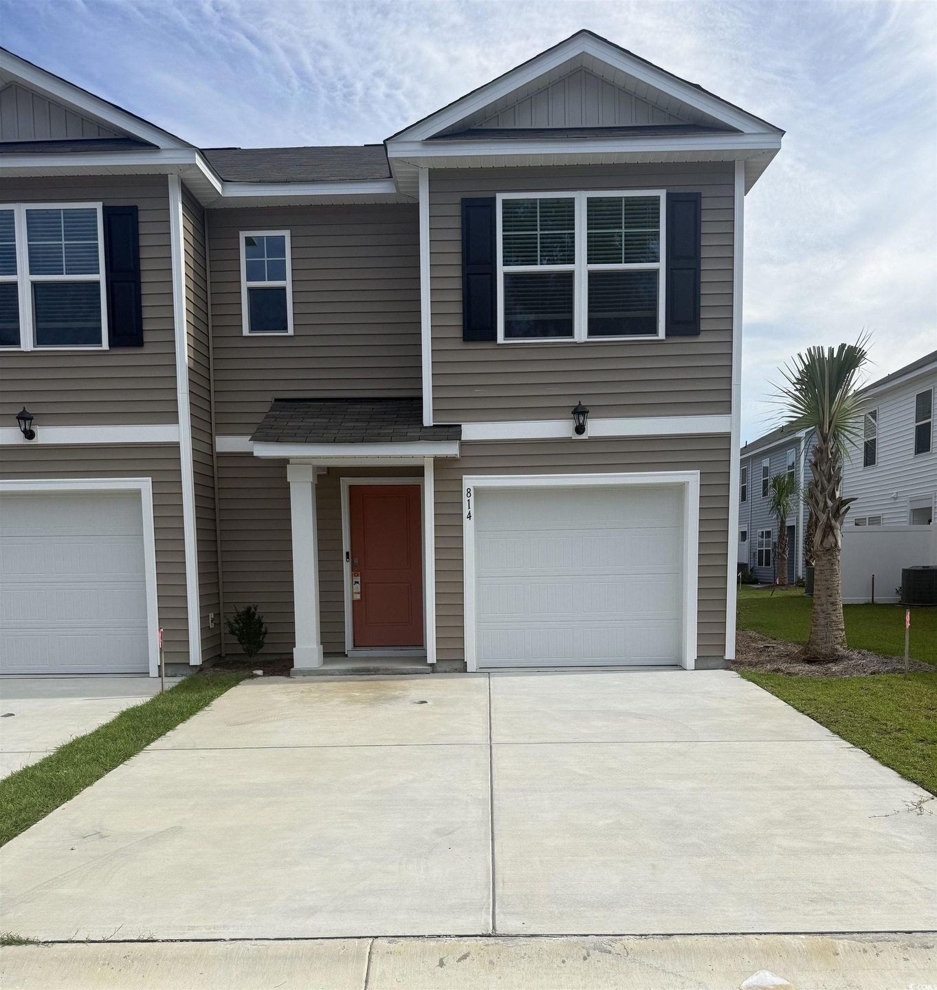 View of front of property with board and batten siding, a garage, and driveway