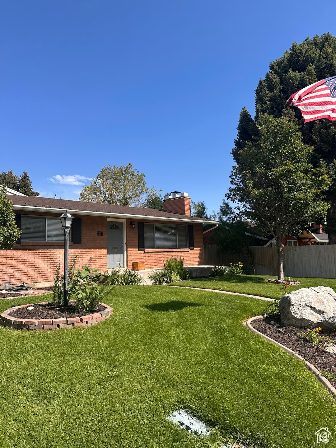 View of front of house featuring brick siding and a chimney