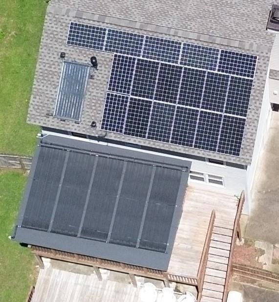View of Solar power system in two levels - lower level of 5 panels containing 100 tubes each provide heated water for pool, upper level powers the home.