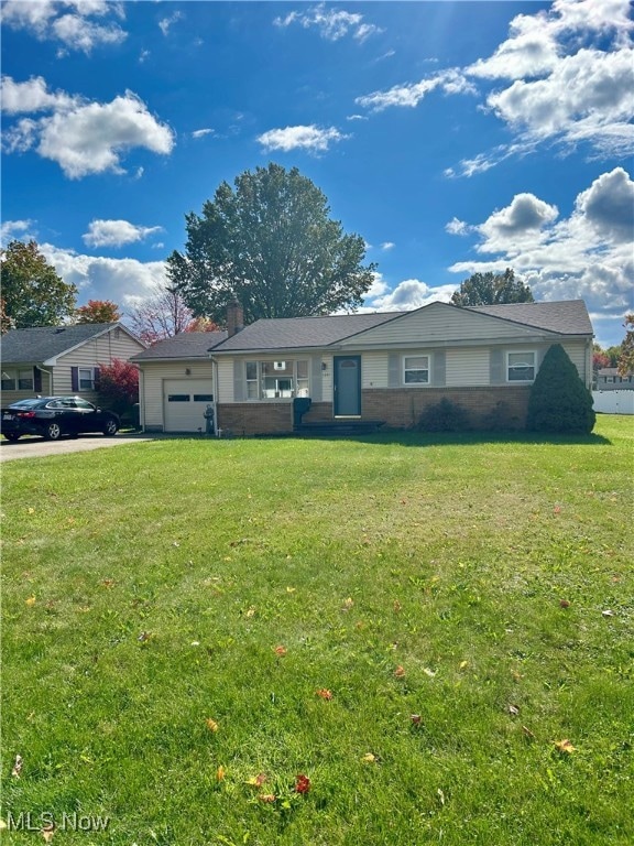 Ranch-style home with a front lawn, an attached garage, brick siding, and driveway