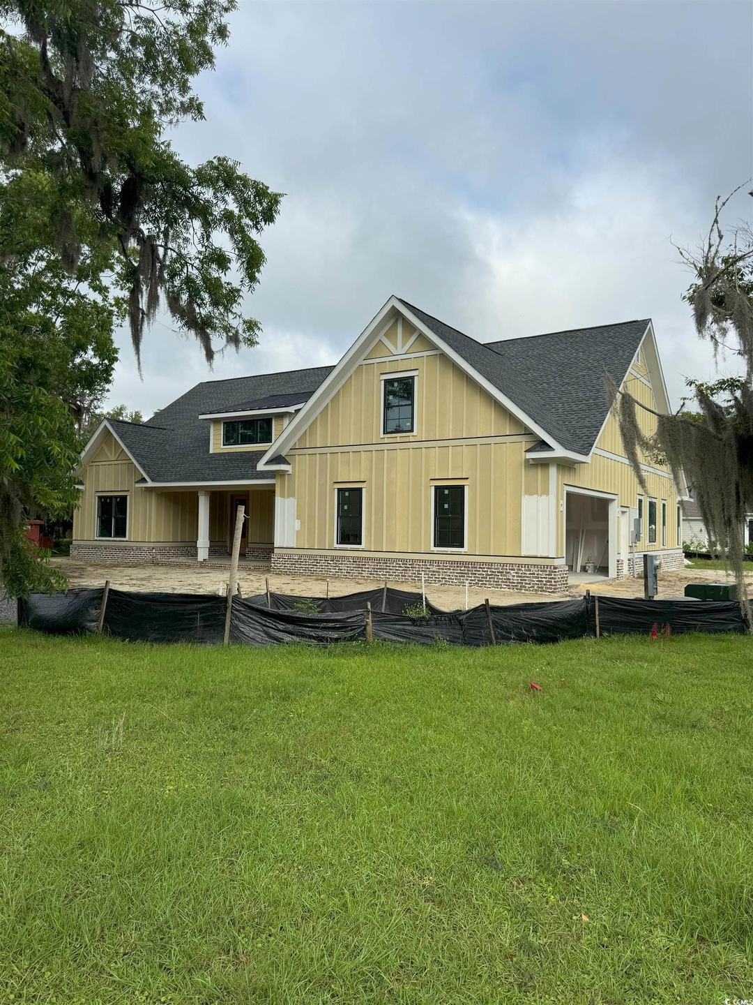 Back of house featuring a lawn, a shingled roof, and board and batten siding