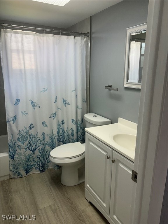 Bathroom with wood finished floors, vanity, toilet