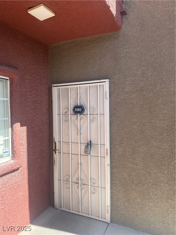 Doorway to property featuring stucco siding