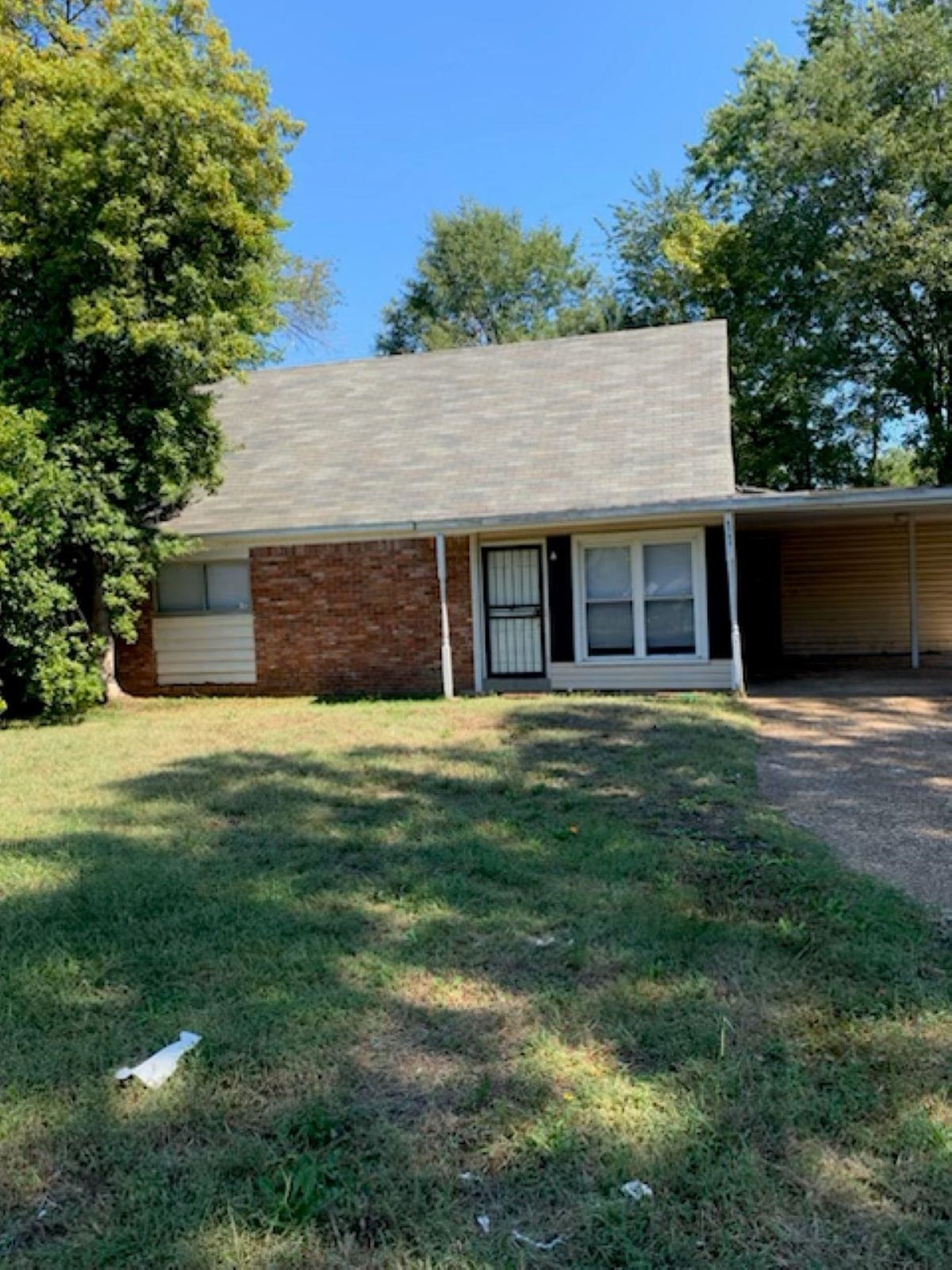 Single story home with a front yard and a carport