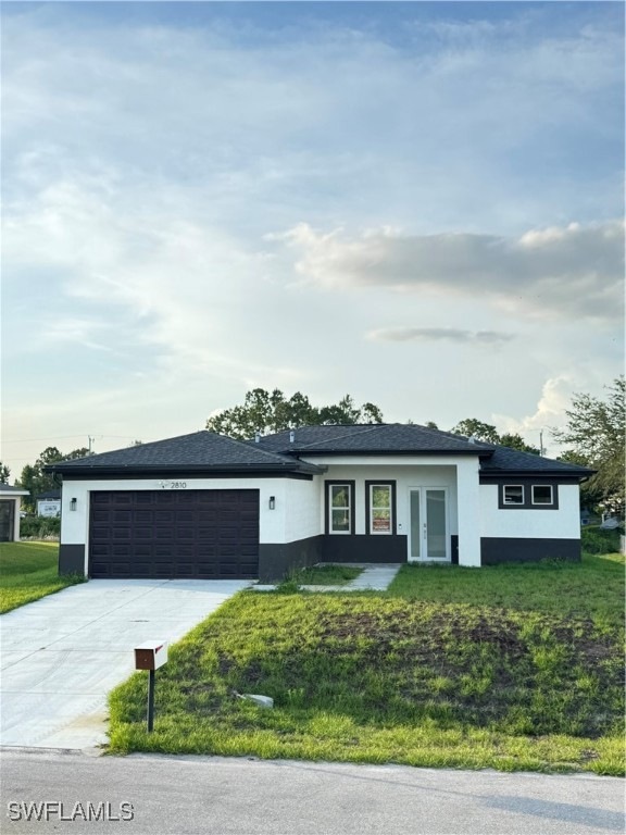 View of front of home with stucco siding, an attac