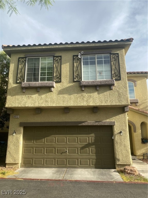 View of front of home with an attached garage, stu
