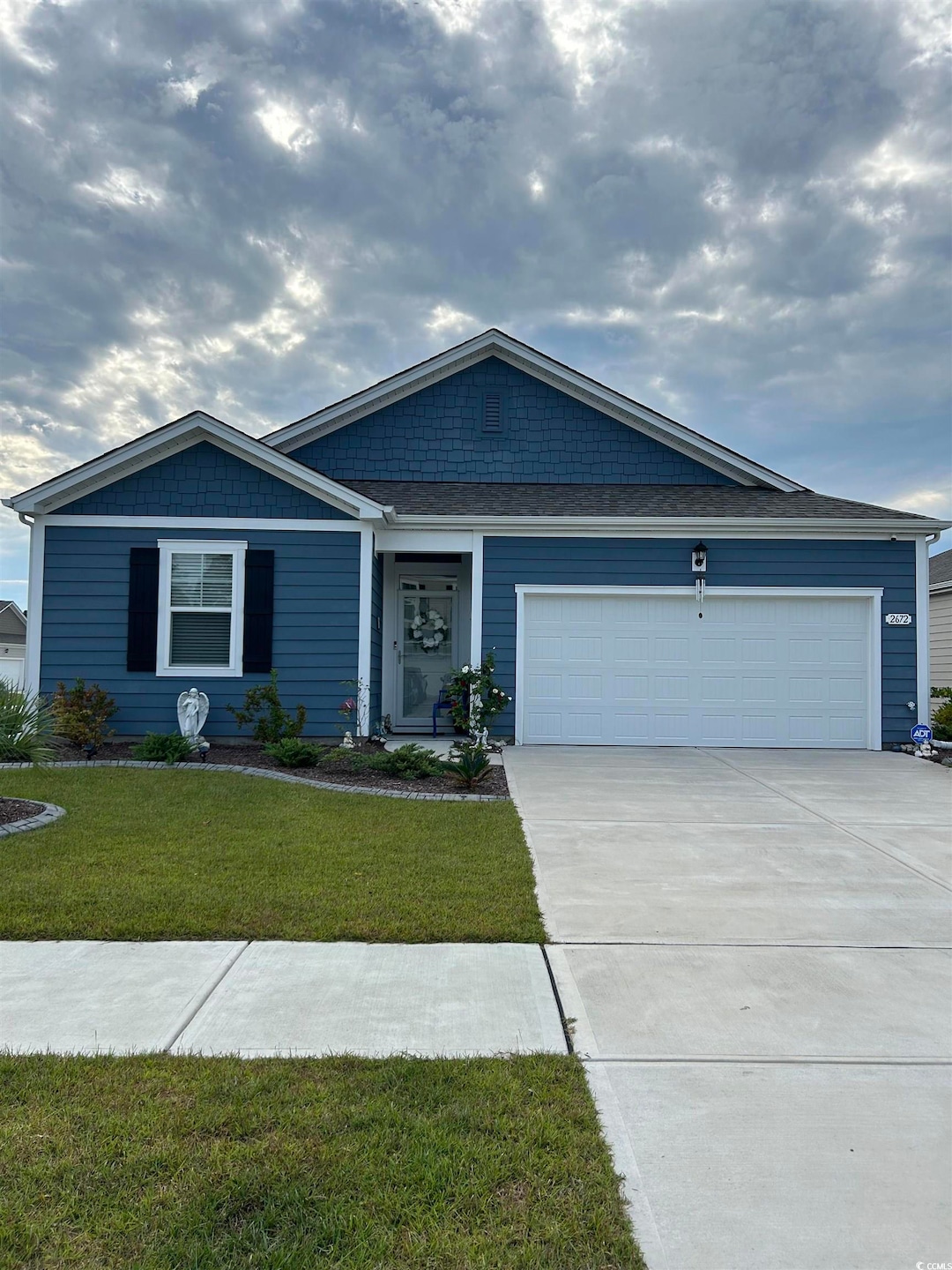 Ranch-style house featuring a front yard and a gar